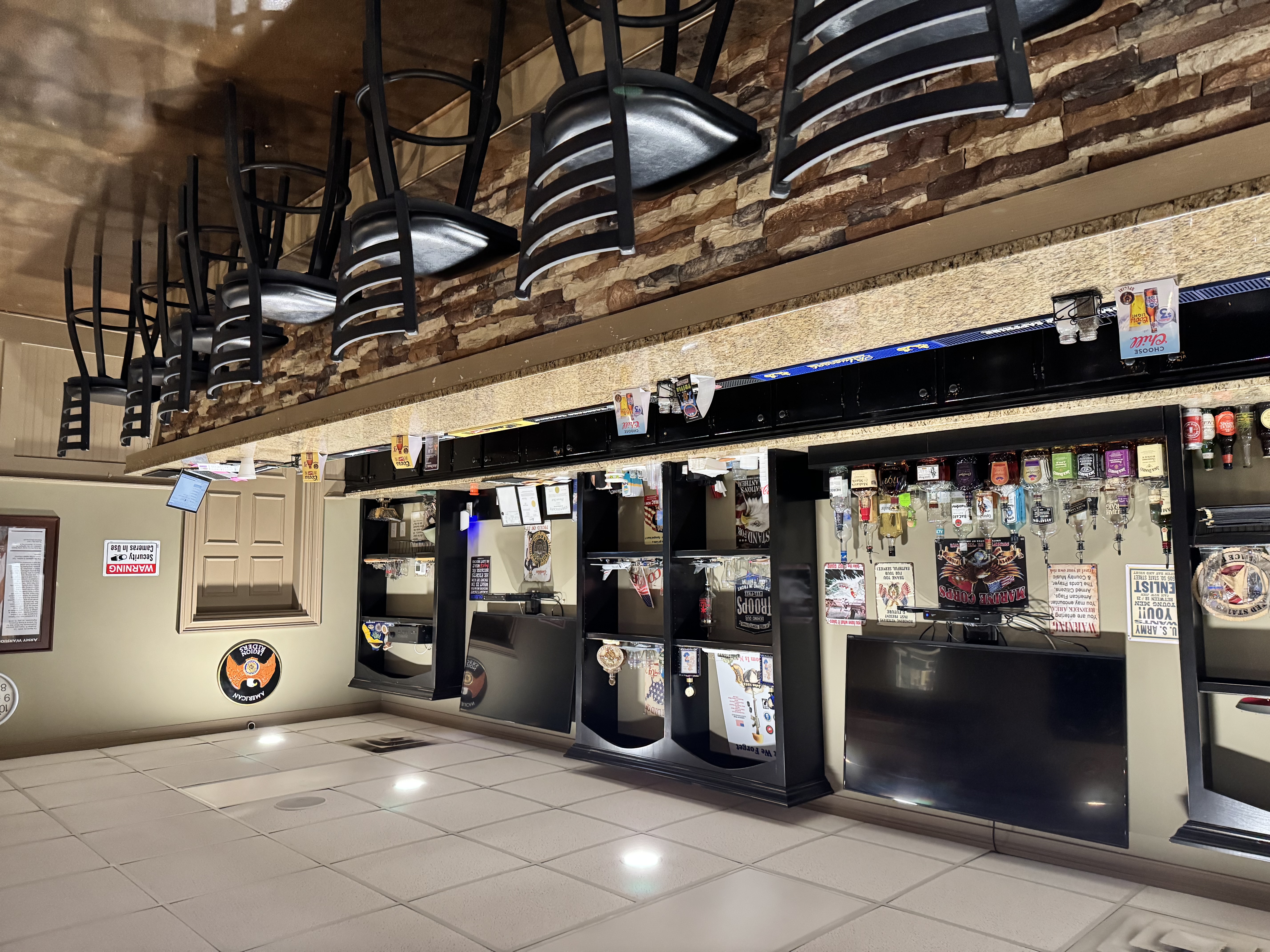 The bar at Patriots' Grill, with stools along a granite counter and a stone facade.